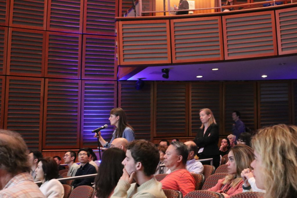 an audience member asks a question of a presenter